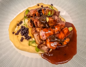 Vazia black angus com batata trufada, couve e trompetas